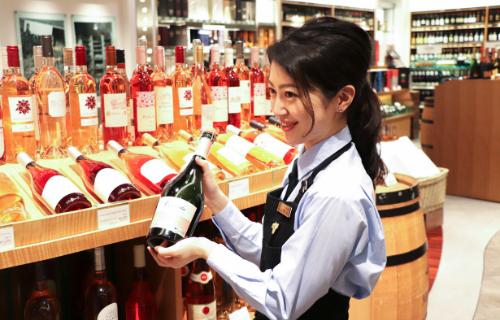 店頭でお客様にワインの提案をするスタッフ